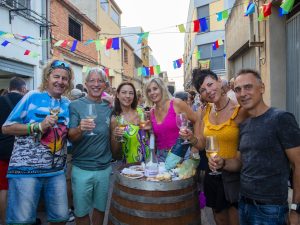 Grupo de asistentes brindando junto a una barrica en una edición anterior de la fiesta.