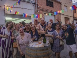 Grupo de asistentes reunido alrededor de una barrica durante la fiesta.